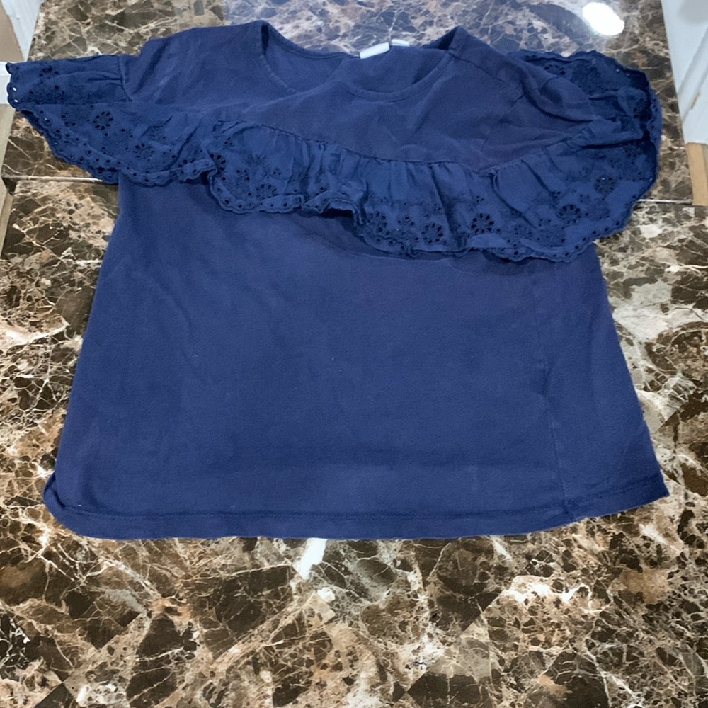 A blue top with a fringe around the shoulders